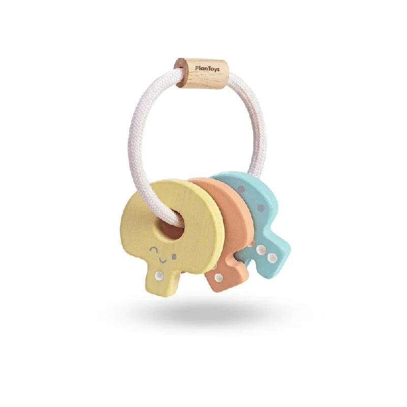 Wooden spinning tops for kinetic fun​ Plan Toys pastel key rattle